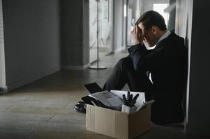 triste despedido empresario sentado fuera de reunión habitación después siendo despedido. foto