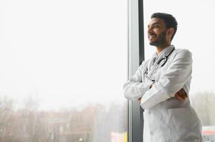 Portrait of confident Asian Indian medical doctor standing at hospital building photo