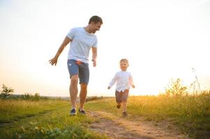 contento padre jugando con hijo en puesta de sol antecedentes .el concepto de del padre día foto