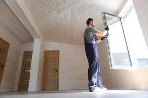 A worker installs windows in a new modular home. The concept of a new home. photo