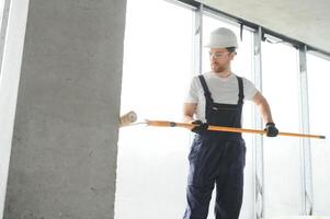 Worker renewing apartment on wall background. photo