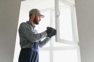 trabajador de la construcción instalando ventana en casa foto