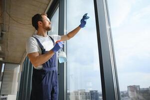 An employee of a professional cleaning service washes the glass of the windows of the building. Showcase cleaning for shops and businesses. photo