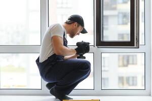 Servicio hombre instalando ventana con medida cinta foto