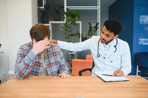 Indian doctor in white gown seeing patients in office. photo