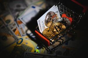 Close up heap of golden bitcoin physical coins on top of Euro, dollar banknotes background, high angle view, selective focus photo