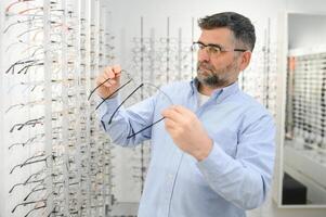 lentes controlar, mayor visión y mayor hombre a un consultante optometría clínica para bienestar. feliz, sonrisa y antiguo cara con lente, marco y gafas elección en un Tienda para ayuda consiguiendo un prescripción. foto