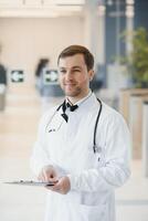retrato de sonriente médico en uniforme en pie en medicina clínica salón foto