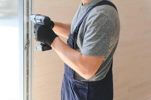 The worker installing and checking window in the house. Concept of new modular houses. photo