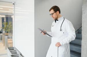 médico con estetoscopio en escalera en hospital. espacio para texto foto