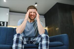 Morning of young man suffering from hangover at home photo