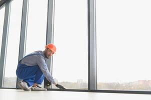 The foreman installs a window frame in the room photo