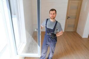 el trabajador instalando y comprobación ventana en el casa. concepto de nuevo modular casas foto