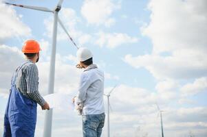 dos asiático ingenieros masculino comprobación viento turbinas renovable energía tecnología y sostenibilidad. alternativa energía para futuro. foto