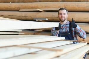 Male Worker folds boards. Sawmill. Wood harvesting process photo