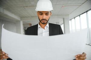 architecture, construction business and building concept - happy smiling indian male architect in helmet. photo