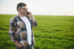 Experienced and confident farmer on his field. Portrait of senior farmer agronomist in wheat field. photo