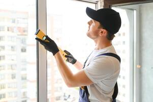 Construction worker repairing plastic window indoors, space for text. Banner design photo