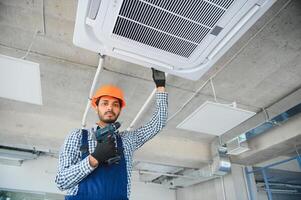 specialist cleans and repairs the wall air conditioner photo