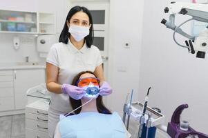 Teeth whitening for woman. Bleaching of the teeth at dentist clinic. photo