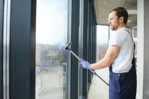 An employee of a professional cleaning service washes the glass of the windows of the building. Showcase cleaning for shops and businesses. photo