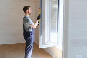 trabajador de la construcción instalando una nueva ventana en casa foto