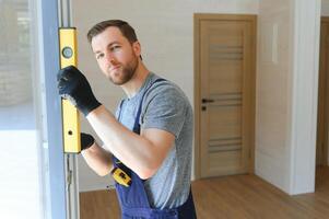 Construction worker installing new window in house photo