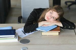 A cute schoolgirl is sitting at a desk at school. The concept of schooling. photo