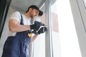 Construction worker repairing plastic window indoors, space for text. Banner design photo