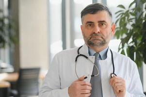 retrato de un mayor médico en su oficina en un hospital foto