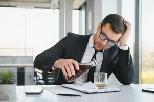 Young businessman drinking from stress photo