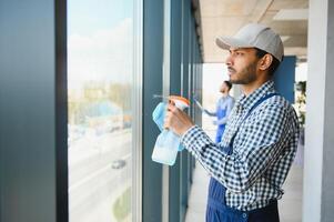 masculino portero limpieza ventana en oficina foto