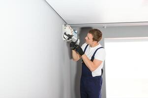 Male technician fixing air conditioner indoors photo