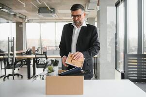 antiguo empleado dejando oficina con el caja lleno de pertenencias foto