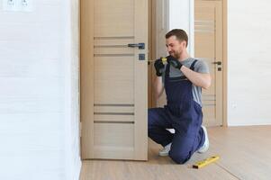 handsome young man installing a door in a new house construction site. photo