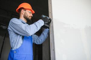 Workers install a plasterboard wall. photo