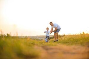 Father help his son ride a bicycle photo