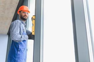 The foreman installs a window frame in the room photo