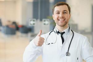 retrato de sonriente médico en uniforme en pie en medicina clínica salón foto