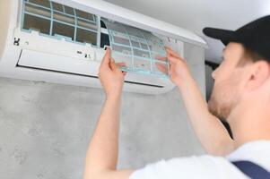 Service man is cleaning, repair and maintenance of air conditioner. photo