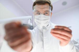 Young male dentist in clinic photo