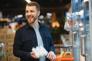 Man holding egg box in supermarket. egg box buy carton man hold checking consumer concept photo