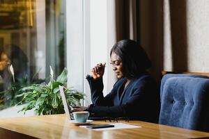 happy young african american businesswoman using computer in office photo