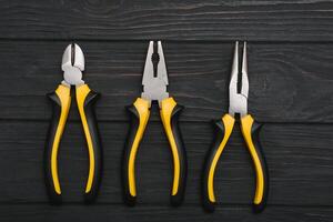 Set of assorted work carpentry and locksmith tools on a dark wooden background with copy space photo