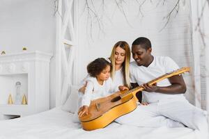 Family laying down together in a bed photo