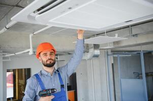 technician service checking and repairing air conditioner indoors photo