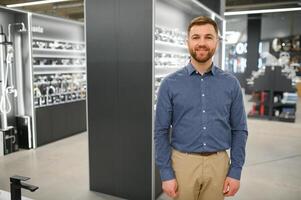 Portrait of salesperson in bathroom store. Happy man works in bath store. Sales occupation photo