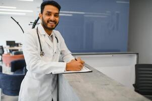 retrato de confidente asiático indio médico médico en pie a hospital edificio foto
