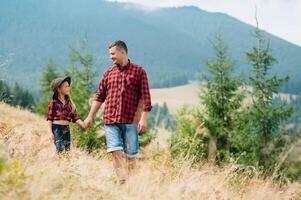 Happy father and little child are walking in the mountains. Father's Day. vacation in the national park photo