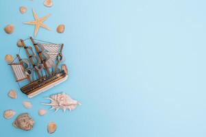 Flat lay. Top view. Frame of shells of various kinds on a blue background. Seashells and starfish and ship on a pastel background. Vacation concept. travel concept. with copy space photo